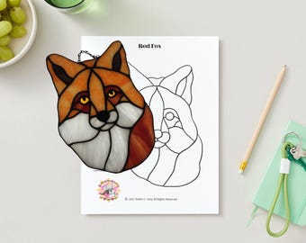 May include: A stained glass red fox head with a chain hanging from the top. The fox has orange, white, and brown glass pieces. The image also includes a black and white outline of a fox head.