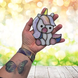Baby Unicorn suncatcher being held to show size. Approximately 5" at tallest area.