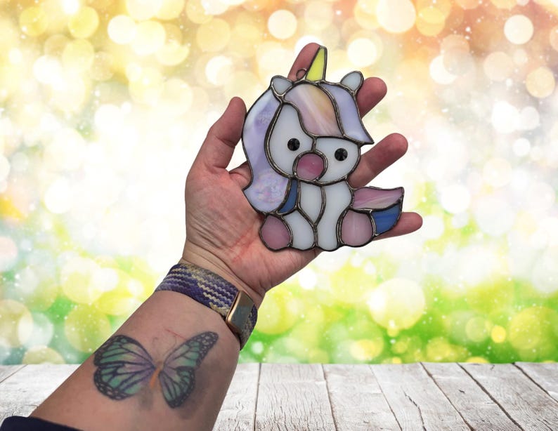 Baby Unicorn suncatcher being held to show size. Approximately 5" at tallest area.