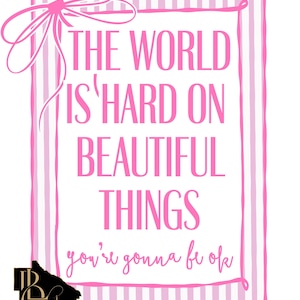 Pode incluir: Uma impressão emoldurada em rosa e branco com o texto "THE WORLD IS HARD ON BEAUTIFUL THINGS you're gonna be ok". A impressão tem um fundo listrado e um laço no canto superior esquerdo.
