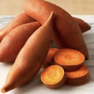 May include: A collection of fresh, raw sweet potatoes. The image shows whole sweet potatoes with a reddish-brown skin, alongside several slices revealing the vibrant orange flesh. The composition highlights the natural color and texture of the root vegetables.