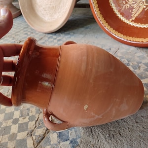 This authentic Moroccan tangia represents centuries-old cooking traditions from Marrakech. Made from sturdy ceramic, this cooking pot is designed for the unique preparation of tanjia - where meat becomes incredibly tender through slow baking in ashes. The terracotta material provides excellent heat retention while the wide base accommodates generous portions. Each handmade piece shows slight variations, proof of its artisanal Moroccan ceramic heritage.