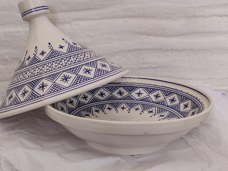 Bring home the charm of North African ceramics with this White ceramic tagine, a fusion of classic craftsmanship and modern aesthetics. Perfect as a serving tagine or for traditional recipes, its handcrafted ceramic body and blue geometric motifs reflect true Moroccan artistry. Whether used as a cooking tagine or displayed as pottery tagine ceramic, it makes a timeless statement rooted in Safi and Fez traditions.