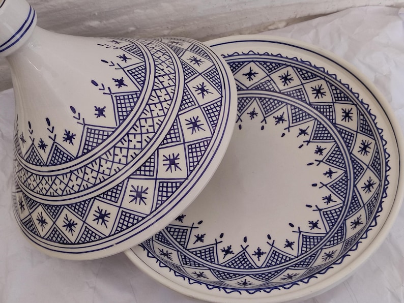 Experience the beauty of Blue Moroccan tagine craftsmanship with this unique piece from Fez pottery. Adorned with geometric star design, this clay tajine pot is perfect for slow-cooked meals and elegant table service. The combination of ceramic tagine body and handcrafted ceramic detail makes it an ideal gift or collector’s item. A true icon of moroccan cooking and North African ceramics.