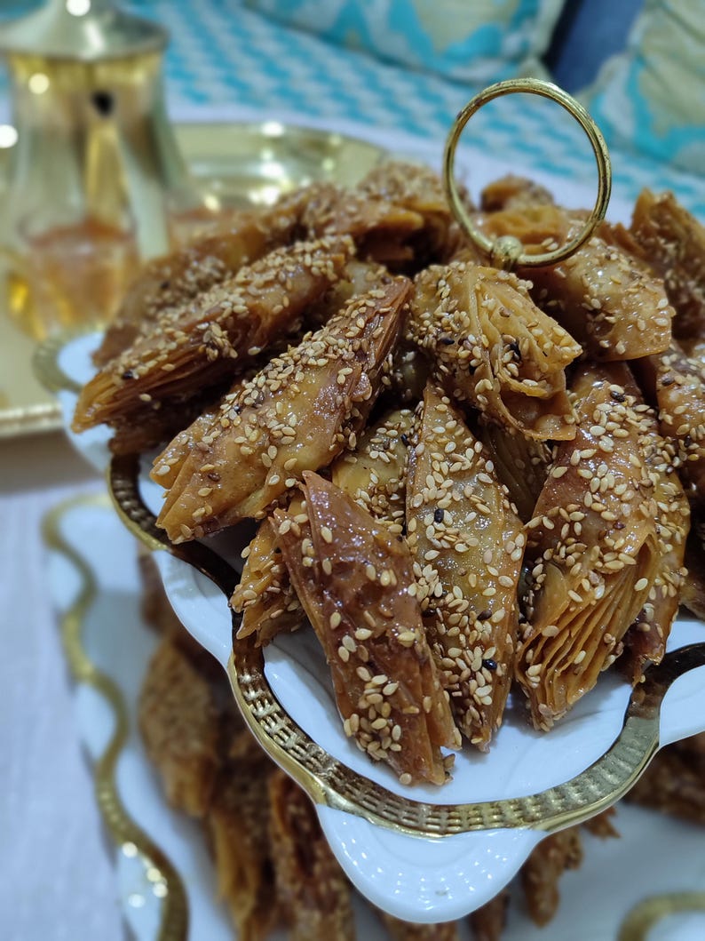 These Authentic Chbakia are the quintessential ramadan sweets found in every Moroccan home during the holy month. Also spelled chebakia, these intricate moroccan pastries are shaped into flowers or butterflies, fried until crisp, then immersed in honey and garnished with sesame seeds. The dough is infused with exotic spices like anise, cinnamon, and saffron, creating a unique flavor profile that defines moroccan tradition. Perfect as eid sweets or daily treats,