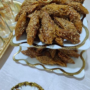 Indulge in the rich flavors of moroccan sweets with this delightful assortment of Lsan Lasfour and chebakia. These handmade moroccan cookies are crafted with precision, using only the finest ingredients including pure honey, sesame seeds, and aromatic spices. Each variety offers a distinct texture and taste, celebrating the diversity of moroccan pastries. Whether served as ramadan treats, eid sweets, or enjoyed with afternoon tea, these halal desserts bring the warmth
