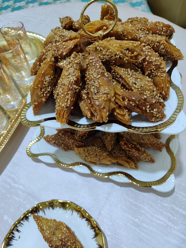 Indulge in the rich flavors of moroccan sweets with this delightful assortment of Lsan Lasfour and chebakia. These handmade moroccan cookies are crafted with precision, using only the finest ingredients including pure honey, sesame seeds, and aromatic spices. Each variety offers a distinct texture and taste, celebrating the diversity of moroccan pastries. Whether served as ramadan treats, eid sweets, or enjoyed with afternoon tea, these halal desserts bring the warmth