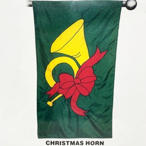 May include: A green Christmas flag with a yellow horn and a red bow. The text "CHRISTMAS HORN" is printed at the bottom of the flag.
