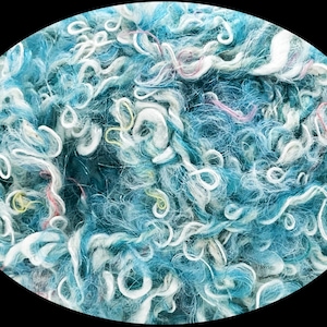 May include: A textured ball of yarn featuring a blend of deep blue, light blue, and white fibers. The yarn has a curly, looped construction with occasional thin strands of yellow and pink thread woven throughout the fuzzy, multi-tonal material.