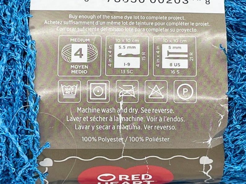 Pode incluir: Uma etiqueta para fio de peso m&eacute;dio, com fio azul vis&iacute;vel. A etiqueta inclui instru&ccedil;&otilde;es de cuidado, medidas em cm e polegadas, e o texto "Lavar e secar na m&aacute;quina. Ver verso."
