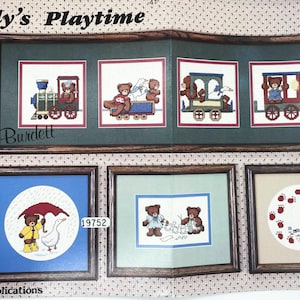 May include: A framed cross-stitch pattern titled "Teddy's Playtime" featuring several scenes with teddy bears. The top frame shows bears on trains, while the bottom frames depict bears with a goose, making paper dolls, and playing.