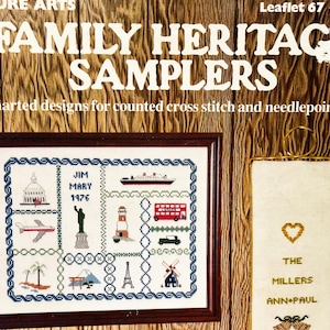 May include: A Leisure Arts Leaflet 67 titled Family Heritage Samplers featuring charted designs for counted cross stitch and needlepoint. The cover displays a framed sampler with travel icons and a vertical hanging sampler with the text The Millers Ann+Paul.
