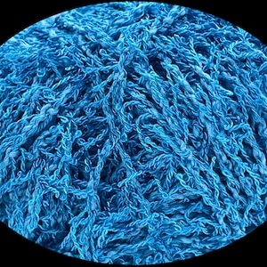 Pode incluir: Close-up de uma bola de fio azul brilhante. O fio parece ser uma fibra texturizada e torcida, possivelmente algod&atilde;o ou l&atilde;, com uma apar&ecirc;ncia ligeiramente difusa. A imagem est&aacute; em um fundo preto.