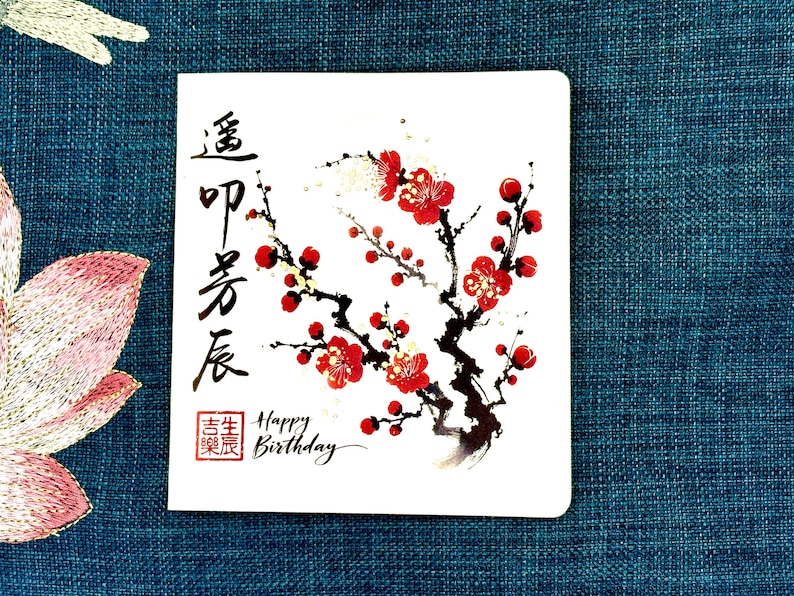 Font side showing happy birthday in English and Chinese. The design  features cherry blossom with gold foil.