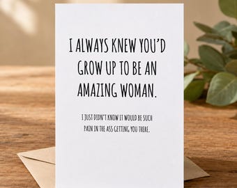 May include: A white greeting card with black text that reads: I ALWAYS KNEW YOU'D GROW UP TO BE AN AMAZING WOMAN. I JUST DIDN'T KNOW IT WOULD BE SUCH PAIN IN THE ASS GETTING YOU THERE. The card is placed on top of a light brown envelope.