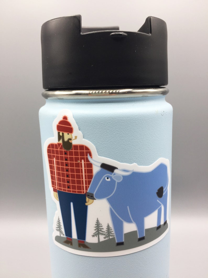 May include: A blue stainless steel water bottle with a black lid. A sticker of a cartoon lumberjack with a red and black checked shirt and a blue ox is on the bottle.