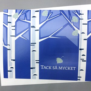 Pu&ograve; includere: Un biglietto blu e bianco con un'immagine stilizzata di betulle e il testo "Tack s&aring; mycket", che si traduce in italiano con "Grazie mille".