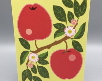 May include: A yellow card with a red apple branch with green leaves and pink flowers. The apples are red with a pink highlight.