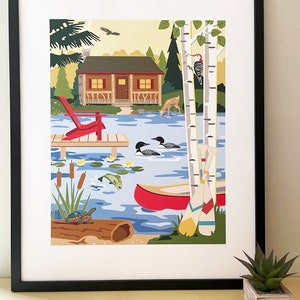 May include: Framed art print depicting a lakeside cabin scene. A red Adirondack chair sits on a wooden dock. The artwork includes a red canoe, birch trees, and wildlife such as deer, loons, and a turtle.