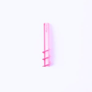 Pode incluir: Uma ferramenta de argila de plástico rosa com um design em espiral. A ferramenta tem o texto "Aqua.day" impresso na lateral. A ferramenta é projetada para moldar e esculpir argila.