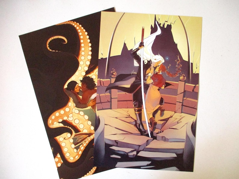 Op de afbeelding: Twee illustraties gedrukt op karton. De eerste illustratie toont een stel dat kust, omringd door een octopus met een donkere achtergrond. De tweede illustratie toont een stel dat op een gebroken stenen platform staat, met een zwaard en een witte cape. De achtergrond is geel en oranje.