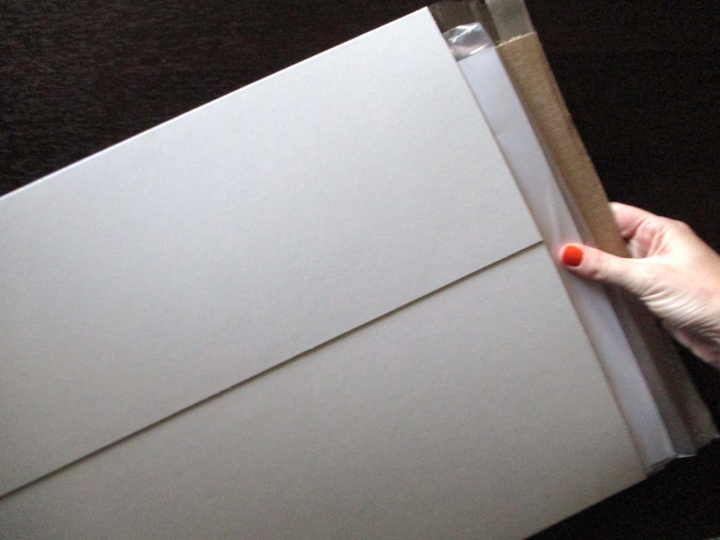 Op de afbeelding: Een witte kartonnen doos met een bruine kartonnen klep. De doos is verzegeld met doorzichtig plakband.