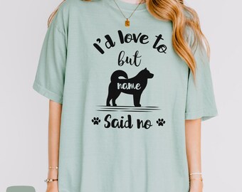 Pode incluir: Uma camiseta verde claro com uma silhueta preta de um cão e o texto "Eu adoraria, mas [name] disse não".
