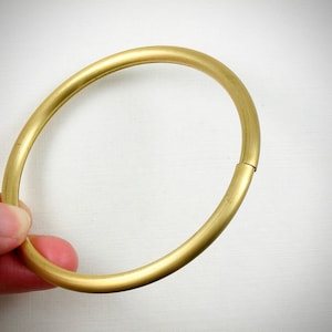 May include: A gold-colored metal ring, open and ready to be used as a key ring or a decorative accent.