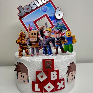Puede incluir: Una tarta de cumplea&ntilde;os con tem&aacute;tica de Roblox con un adorno decorativo con el nombre "Josua" y el n&uacute;mero "6". La tarta est&aacute; adornada con figuras de personajes de Roblox y el logotipo de Roblox en rojo y blanco.