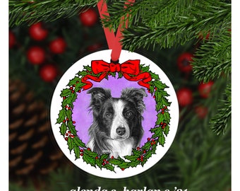 Könnte beinhalten: Runder Weihnachtsschmuck mit einem schwarz-weißen Border Collie-Hundeporträt, umgeben von einem grünen Kranz mit roten Beeren und einer roten Schleife. Der Schmuck hängt an einem roten Band. Der Text unten lautet "glenda s. harlan c.'21".