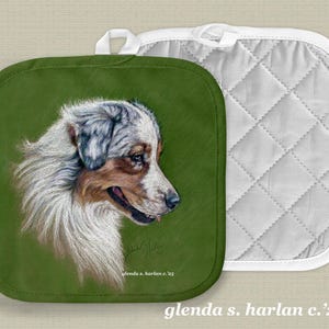 May include: Green pot holder with a white and brown Australian Shepherd dog illustration. The dog is looking to the right. The pot holder has a white quilted back.
