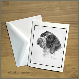May include: A black and white pencil drawing of a dog's head on a greeting card with a black border. The card is next to a white envelope. The text "glenda s. harlan c. '17" is printed on the bottom left corner.