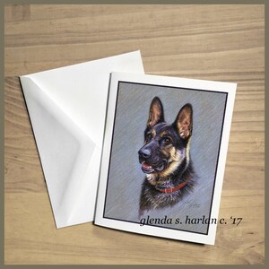 May include: A black and tan German Shepherd dog with a red collar is depicted in a realistic drawing. The dog is looking to the left of the image. The artist's signature and the year '17 are in the bottom right corner of the image.