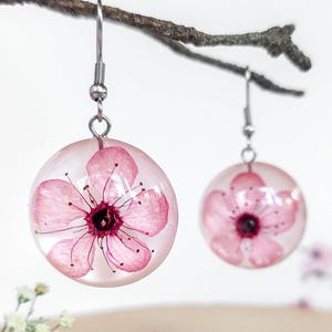 桜のイヤリング、本物の花のイヤリング、ピンクの花のイヤリングのダングル、桜のジュエリー、丸いダングルイヤリング、女性への誕生日プレゼント