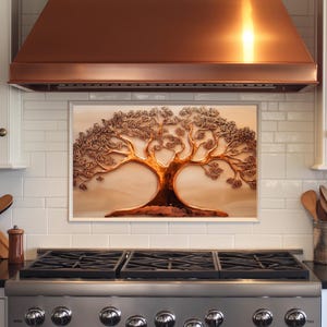 May include: A framed copper-colored tree sculpture with intricate details. The artwork features a large trunk and branches with textured leaves, set against a neutral background. The sculpture is mounted above a stainless steel stove.