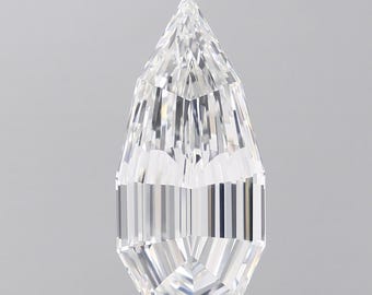 May include: A clear, faceted gemstone with a pear-like shape. The gem has a pointed top and a wide, flat base. The facets create a play of light and shadow, giving the stone a brilliant appearance. The gemstone is set against a neutral gray background.
