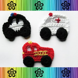 May include: Three crocheted toy vehicles: a black and white police car, a white ambulance with a red cross, and a red fire truck with yellow ladders.
