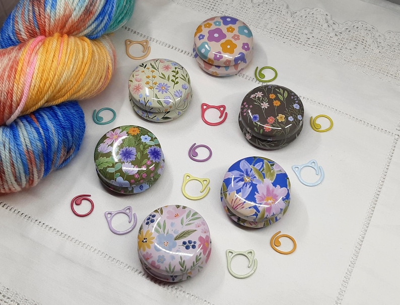 Floral stitch marker tins with painted metal stitch markers. Knitting and crochet notions and accessories.
