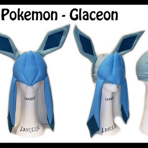 May include: A blue and teal Pokemon Glaceon hat with long ears and a pointed hood. The hat is on a white mannequin head. The text "Pokemon - Glaceon" and "By Lili =^_^=" is at the top of the image.