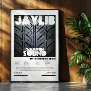 May include: A framed poster featuring the album art for "Jaylib Champion Sound." The artwork displays the album title in bold white letters over a tire tread pattern. The poster includes a tracklist and release date.