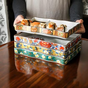 May include: A set of four ceramic serving dishes with colourful floral patterns. The dishes are stacked on top of each other and have a wavy edge.