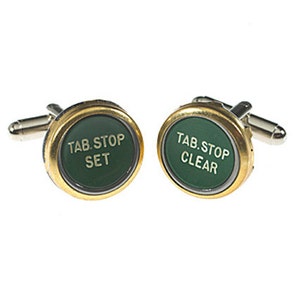 May include: A pair of gold cufflinks with green buttons. The buttons have the text "TAB STOP SET" and "TAB STOP CLEAR" on them.