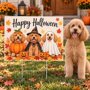 May include: A rectangular yard sign featuring the text Happy Halloween in black script. The illustration shows three golden-colored dogs: one inside a pumpkin, one wearing a witch hat and cape, and one dressed as a ghost, surrounded by autumn leaves.