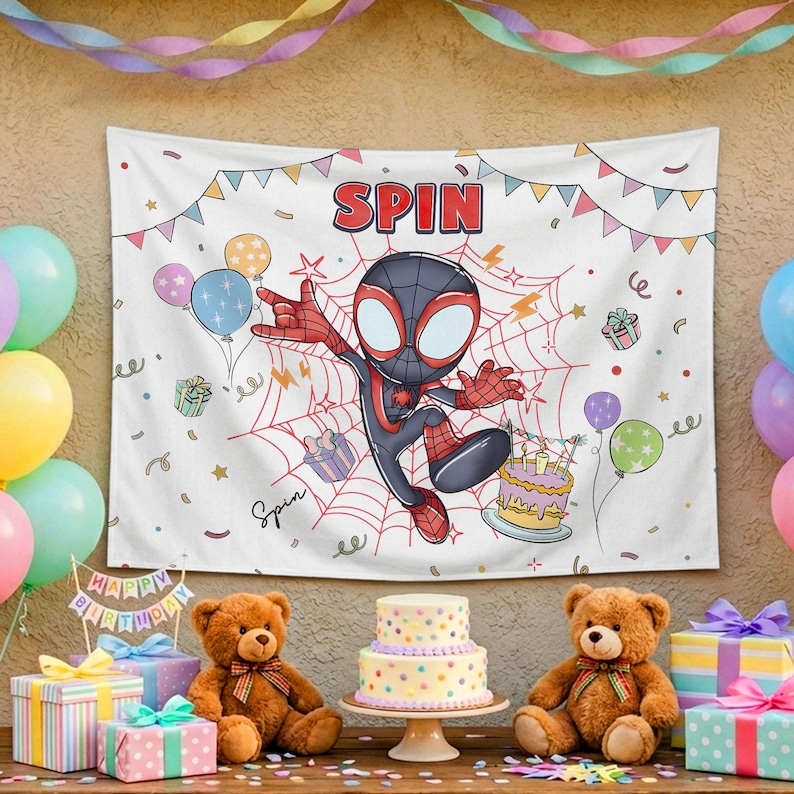 May include: A white rectangular birthday backdrop featuring a cartoon character in a black and red suit, a spider web, colorful balloons, gift boxes, a birthday cake, and the text SPIN. The banner is decorated with triangular bunting flags.