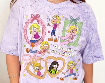 May include: Purple tie-dye t-shirt featuring a graphic print of cartoon characters from the television show "Lizzie McGuire". The characters are in frames and hearts with the words "Lizzie McGuire" spelled out in colourful beads.