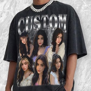May include: Black oversized t-shirt with a distressed vintage look. The front features a graphic design with the word "CUSTOM" above a series of portraits of a woman. A silver chain necklace is visible at the neckline.