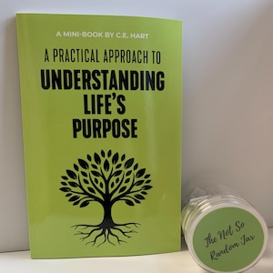 May include: A mini-book titled "A Practical Approach to Understanding Life's Purpose" by C.E. Hart, with a green cover and a tree graphic. Beside it is a jar with a green lid that reads "The Not So Random Jar".