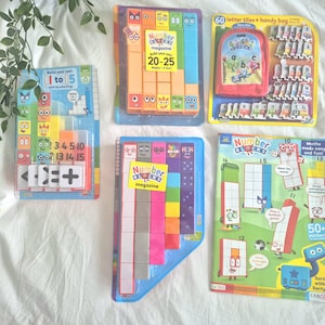 Könnte beinhalten: Eine Sammlung von Numberblocks Lernspielzeug und Aktivitätssets, bestehend aus Kunststoff-Bausteinen mit Charaktergesichtern, einem Set aus 60 Buchstabenplättchen mit roter Aufbewahrungstasche und einem bunten Aktivitätsmagazin mit Zahlenfiguren.