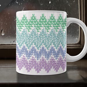 May include: White ceramic mug with a repeating pattern of the words "THE ACTUAL FUCK WHAT" in green, blue, and purple. The mug has a white handle and is set against a window background. Text at the top left says "Choose from TWO SIZES".