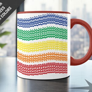 May include: A white ceramic mug with a rainbow design of repeating shapes in blue, green, yellow, orange, and red. The mug has a red handle and rim. Text on the side says "Choose from TWO SIZES & FOUR COLORS".
